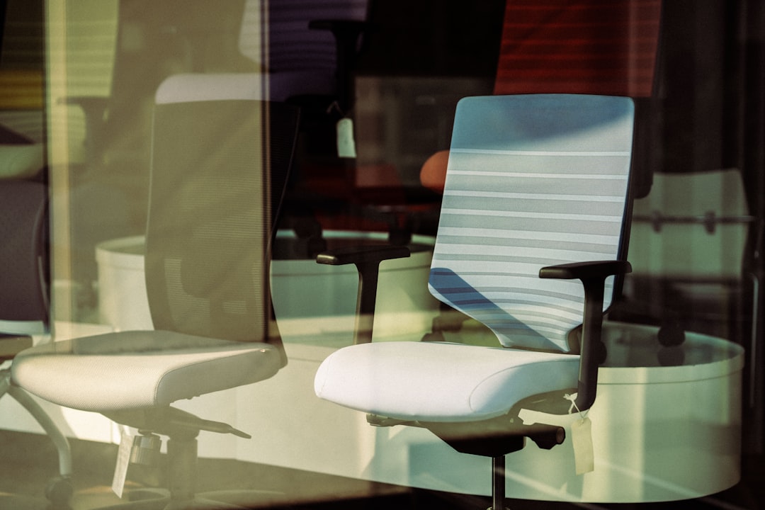 a white office chair sitting in front of a window