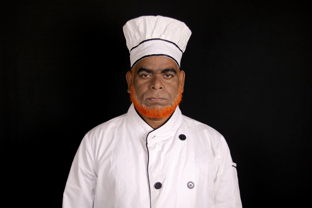 A chef in a white uniform with a tall hat.