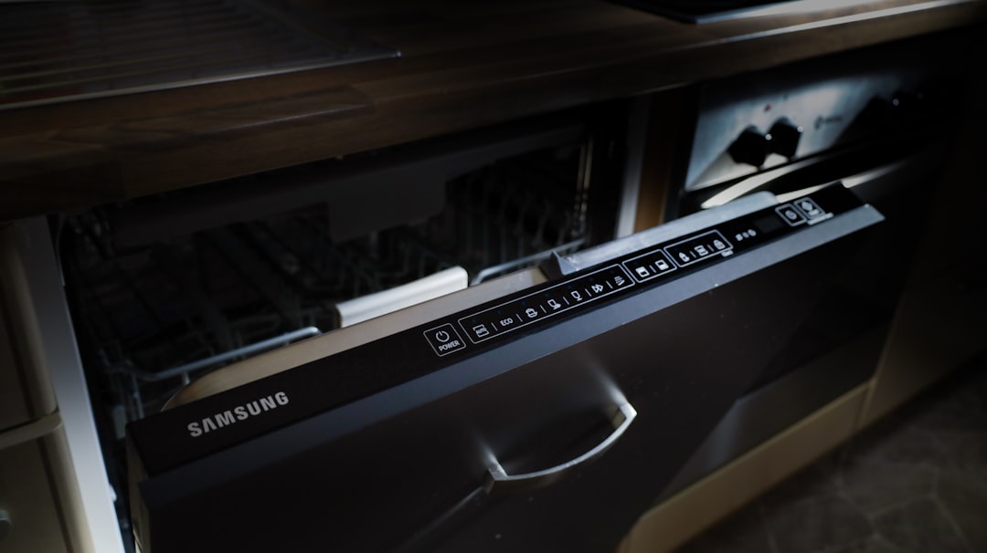 A modern samsung dishwasher drawer built into cabinetry.