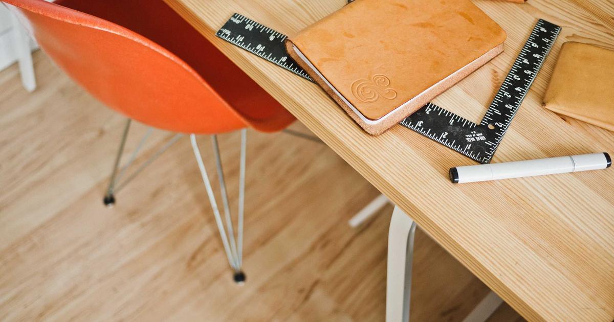 Бамбуковый стебель, растущий сквозь отверстие в металлическом фонарном столбе и выпустивший зелёные листья наверху