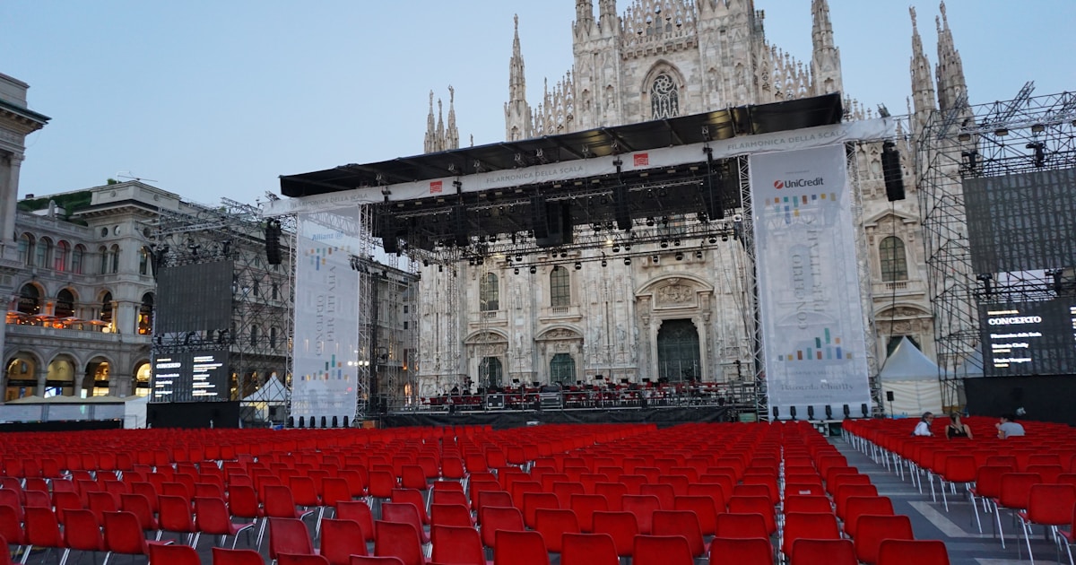 Актёры Хадсон Уильямс и Коннор Сторри несут олимпийский факел по улице итальянского города