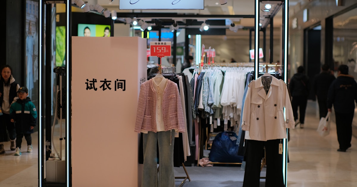 Джинсы разных фасонов на вешалке во время распродажи в магазине