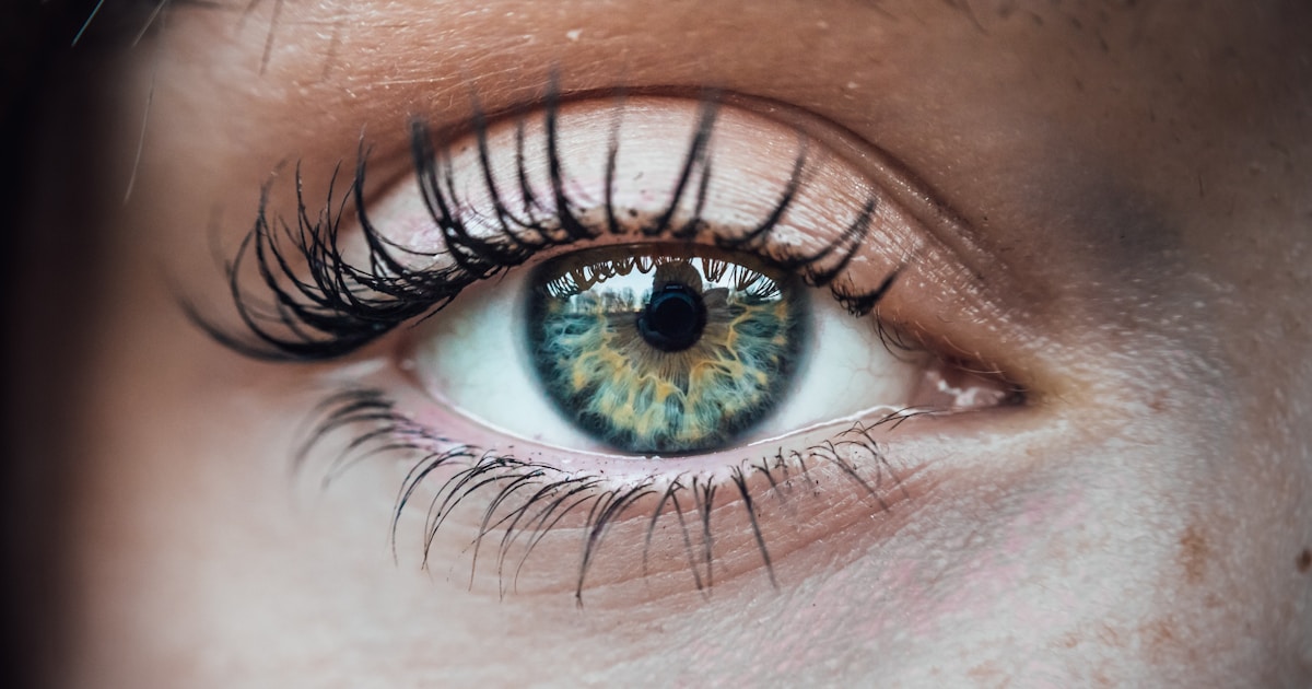 Женщина испытывает дискомфорт от сухости глаз, прикрывая лицо рукой