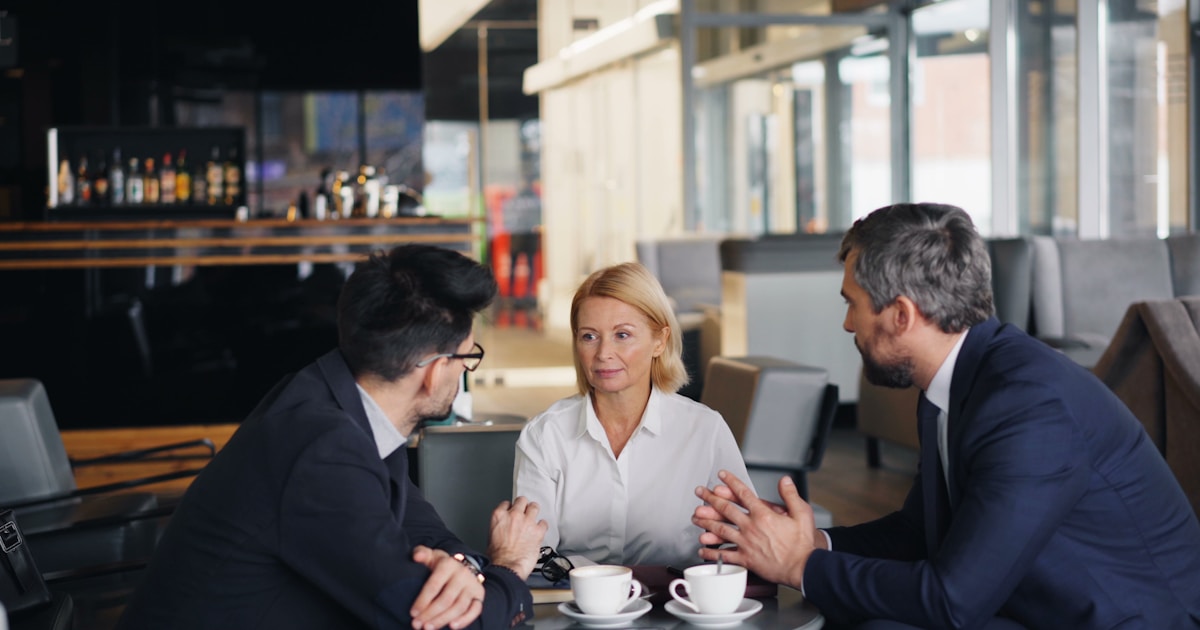 Руководитель и команда на деловой встрече, обсуждающие проект
