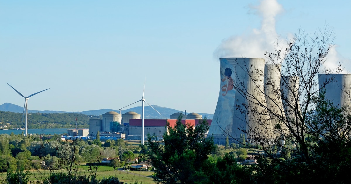 Современная атомная электростанция с реакторами на фоне ясного неба