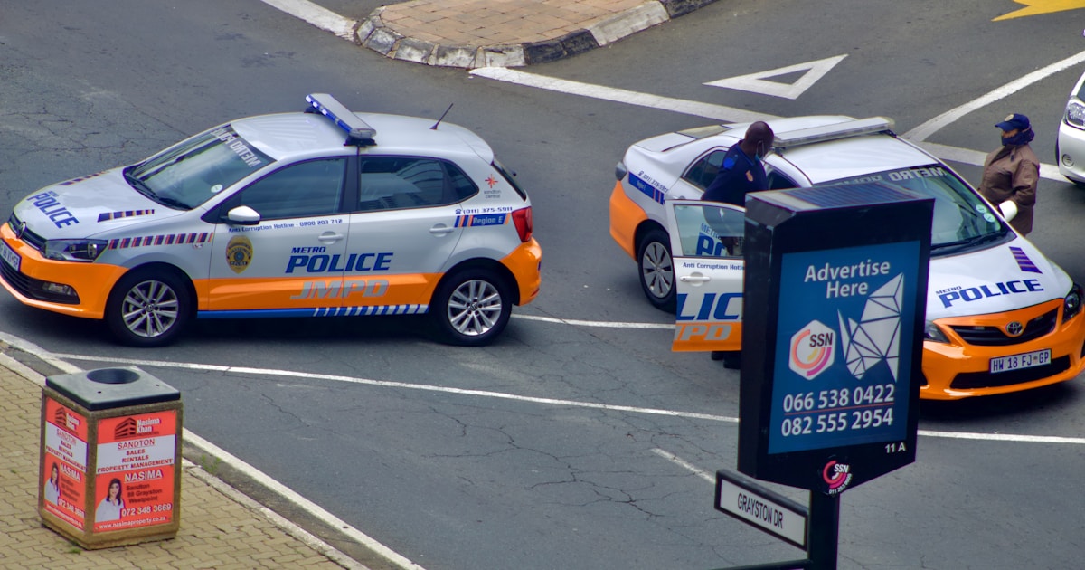 Курьер беседует с полицейскими у служебного автомобиля