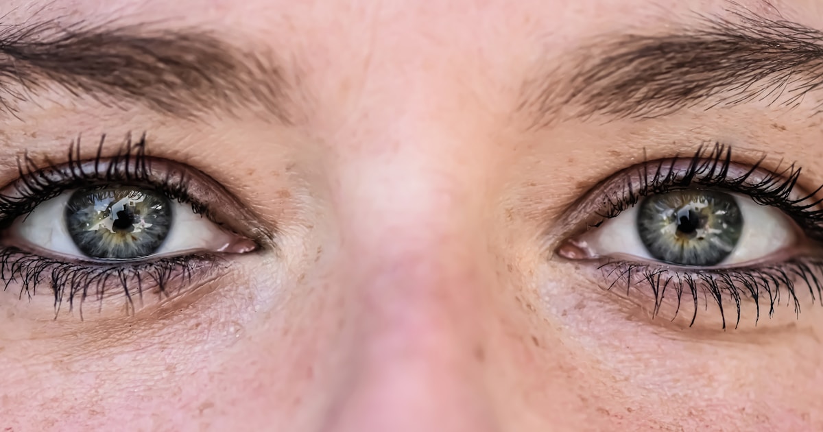 Женщина проверяет упругость кожи на щеке с помощью щипкового теста