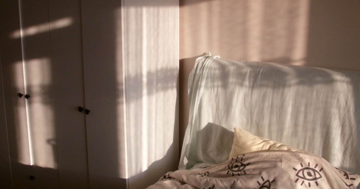 Женщина спокойно спит в уютной постели, символ здорового сна и расслабления