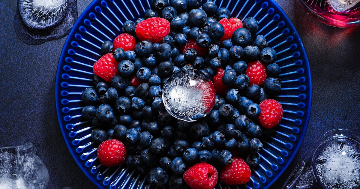 Тарелка с ягодами, куркумой, чесноком и зелёным чаем — продукты, замедляющие старение