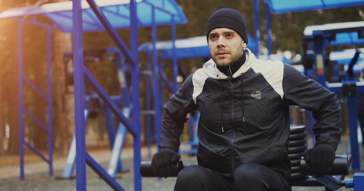 Спортсмен выполняет жим штанги лёжа в тренажёрном зале, демонстрируя силовую тренировку