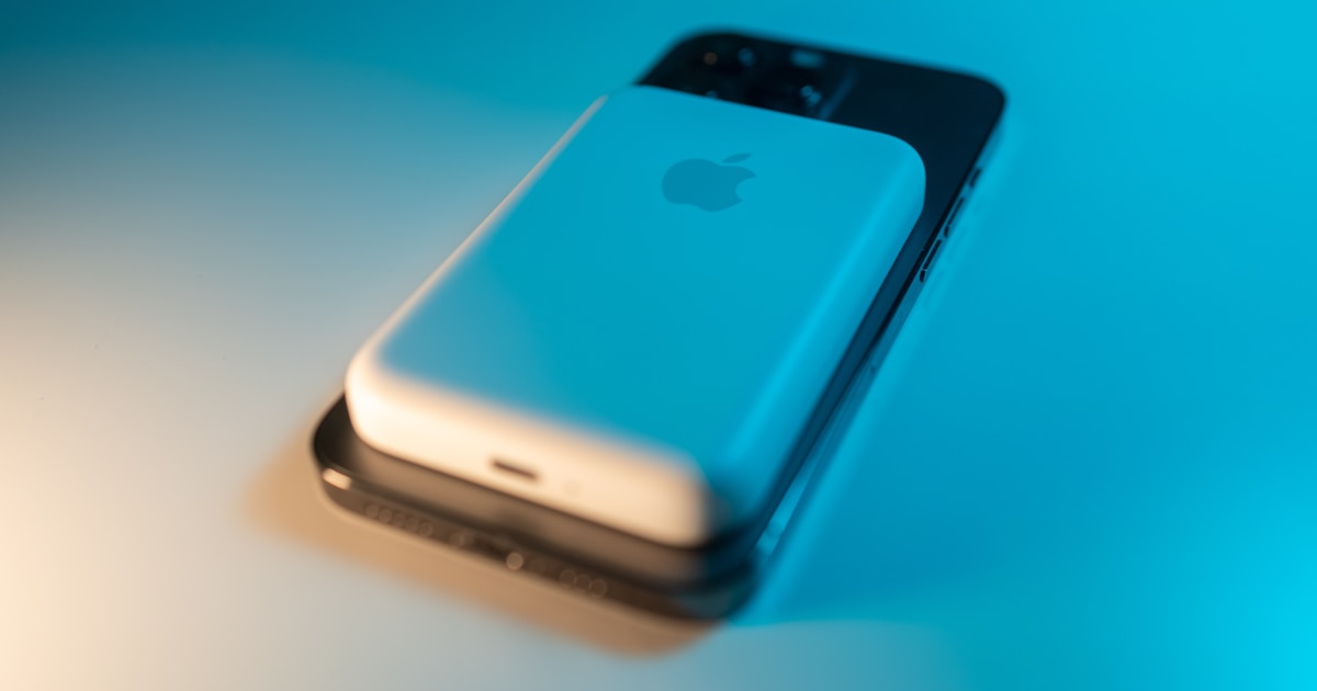 Магнитный повербанк MagSafe прикреплен к задней панели iPhone для беспроводной зарядки