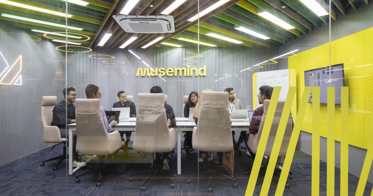 Руководитель обсуждает стратегию с командой на фоне экрана с данными и графиками