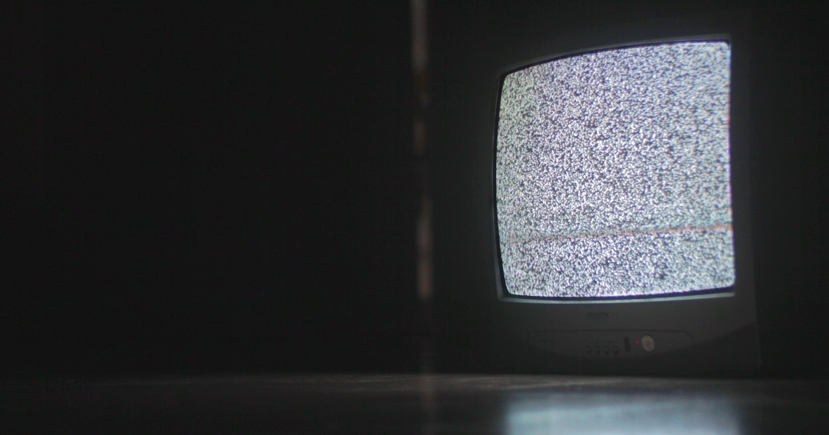 Современный тонкий телевизор с качественным изображением на стене в гостиной