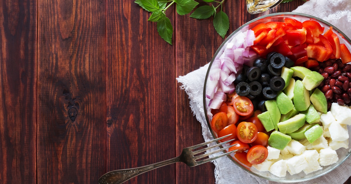 Тарелка с разнообразными продуктами, богатыми белком: куриная грудка, яйца, греческий йогурт, орехи и киноа