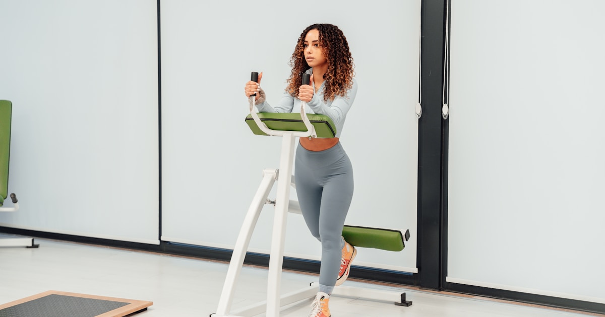 Женщина выполняет функциональное силовое упражнение в спортзале