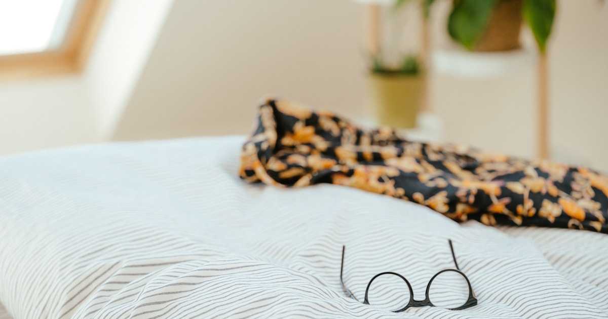 Девушка в очках, блокирующих синий свет, перед сном