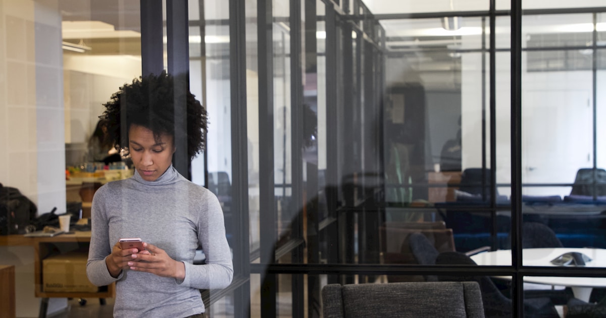 Сотрудники в офисе обсуждают рабочие процессы на фоне мониторов с графиками