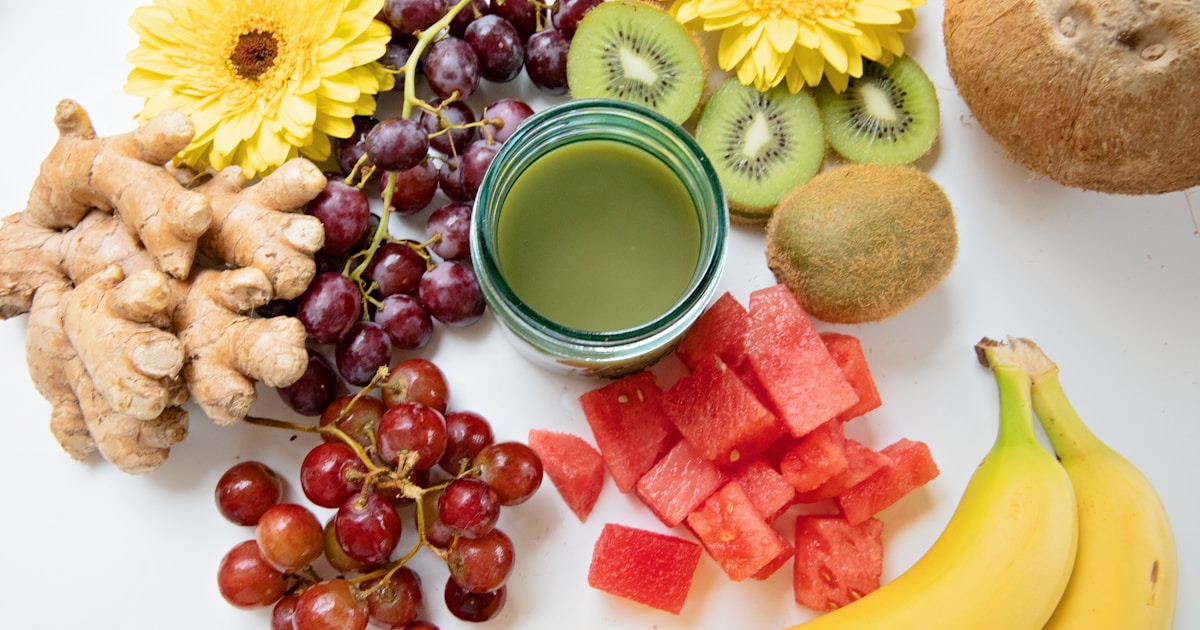 Прозрачный протеиновый напиток в стакане на фоне спортивного инвентаря