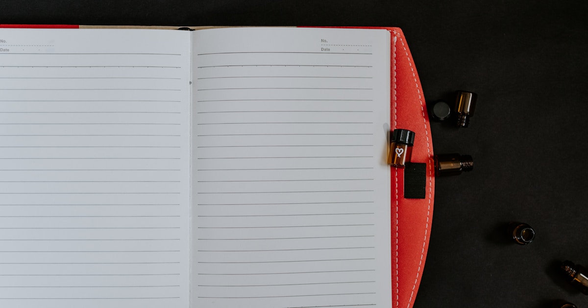 Женщина пишет в блокноте, задумавшись у окна — процесс создания автобиографии и самоанализа