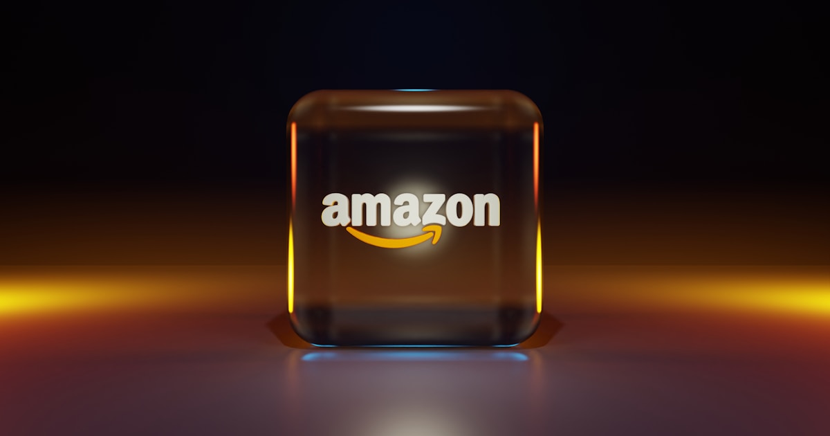 График акций Amazon и логотип компании на экране компьютера