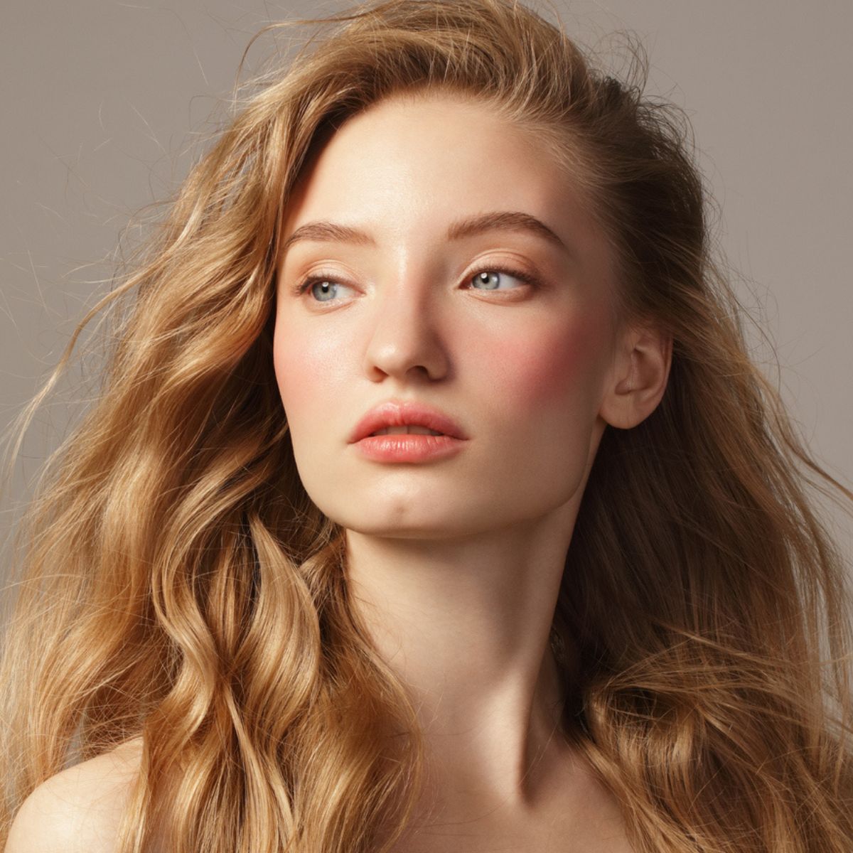 Стилист создаёт объёмную причёску с боковым пробором и мягкими волнами