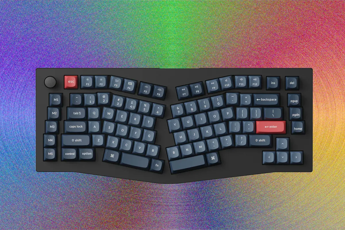 Эргономичная клавиатура на рабочем столе рядом с ноутбуком и мышкой